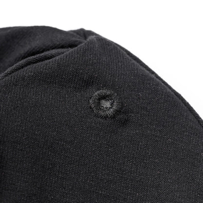 Detailaufnahme der verstärkten Öse auf der schwarzen OBIXS® Handtuchmütze für den verstellbaren Verschluss.