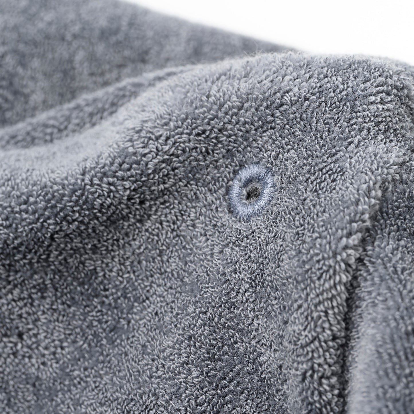 Nahaufnahme des saugstarken grauen Frotté-Innenstoffs mit verstärkter Öse der OBIXS® Handtuchmütze Schwarz.