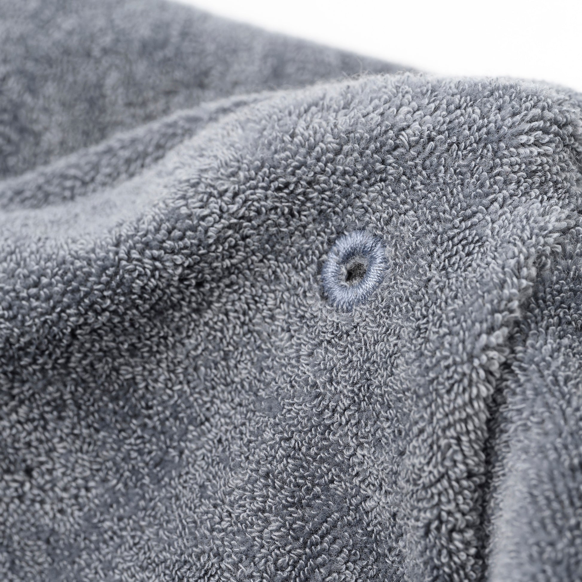 Nahaufnahme des saugstarken grauen Frotté-Innenstoffs mit verstärkter Öse der OBIXS® Handtuchmütze Schwarz.